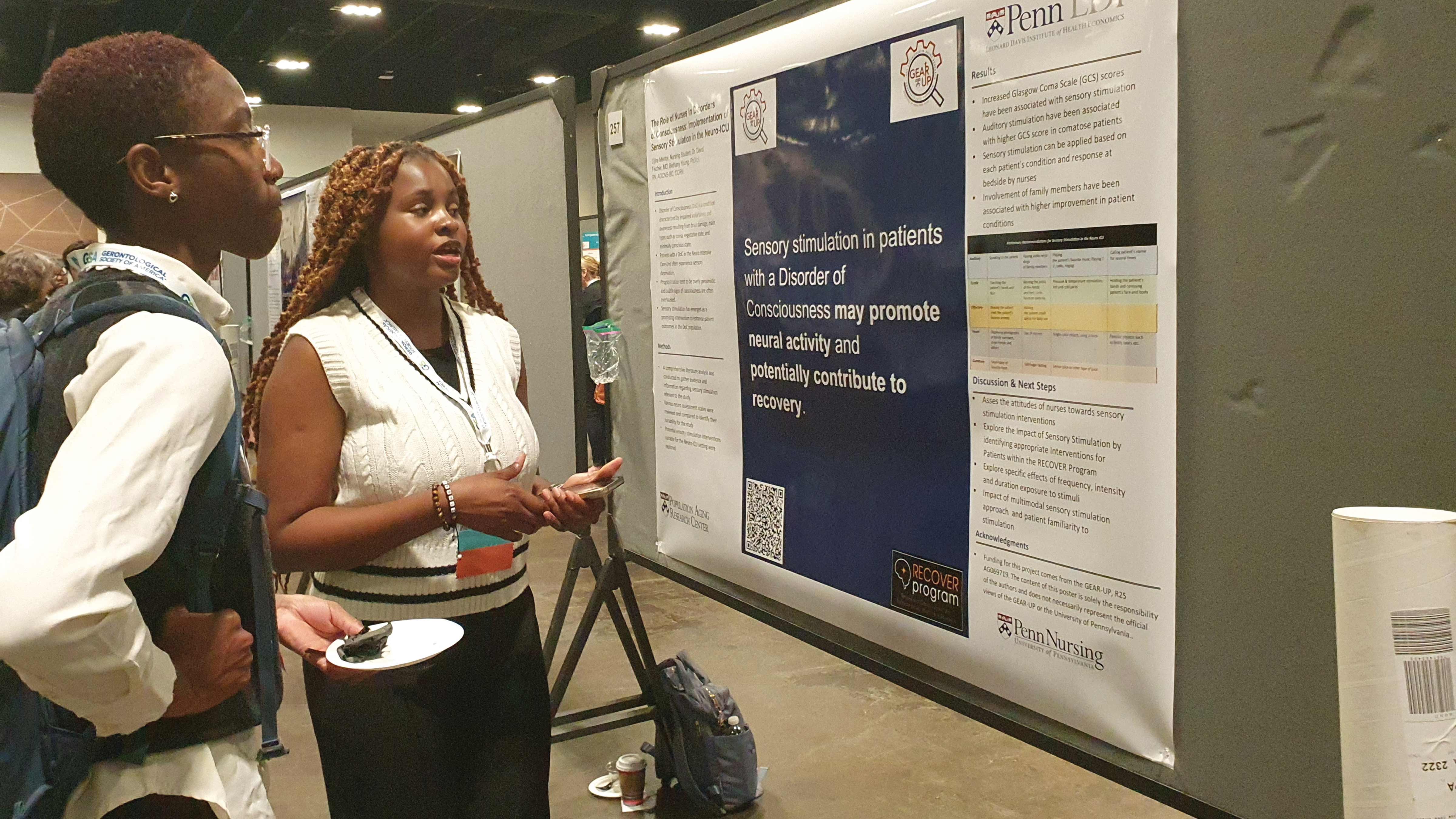 GEAR UP scholar Rhoodjinie Mentor, NU’25 (right), discusses her poster with another attendee at the Gerontological Society of America (GSA) conference in November 2023
