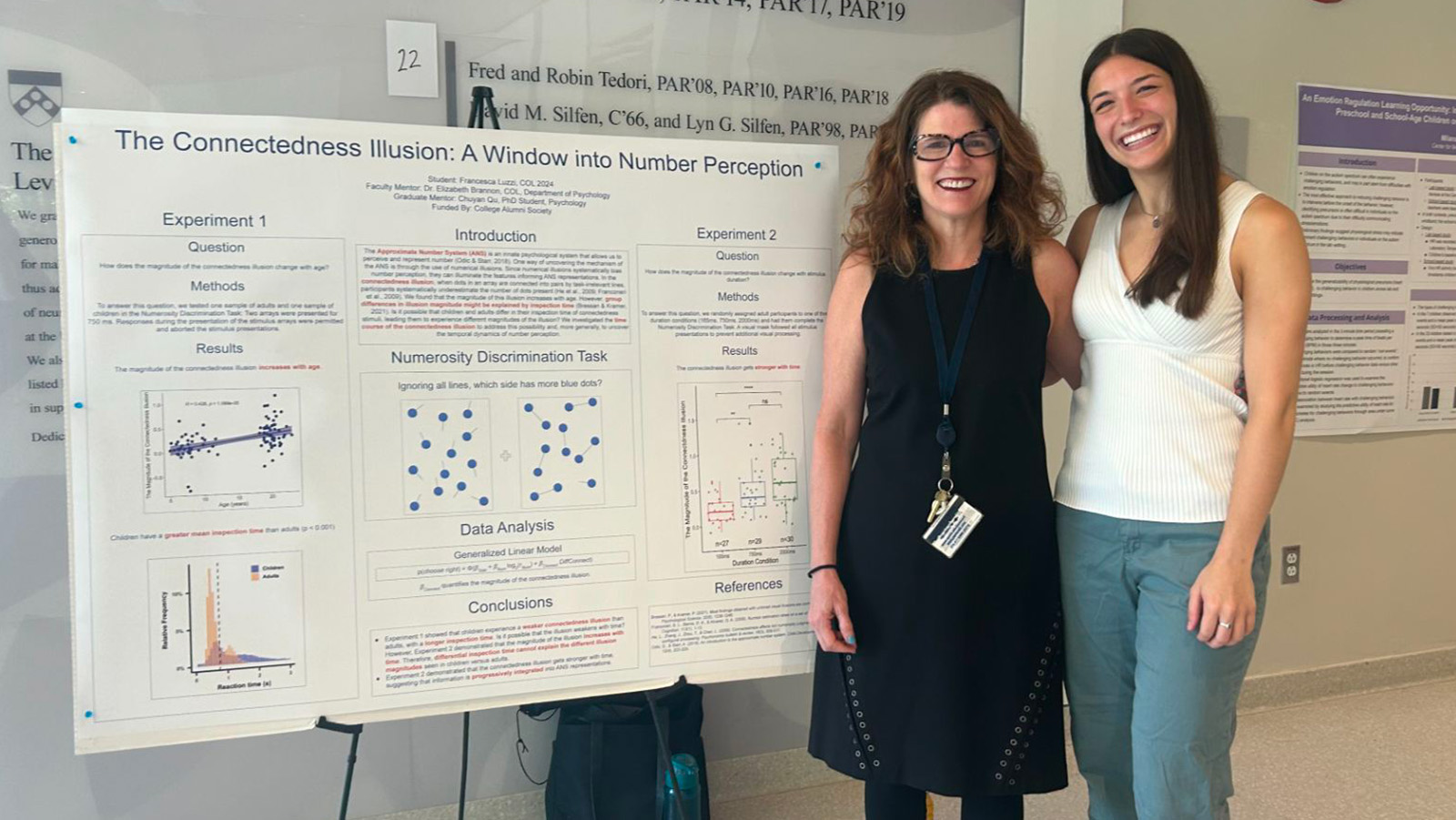 Professor Liz Brannon and Francesca Luzzi stand in front of a poster detailing research Luzzi conducted.