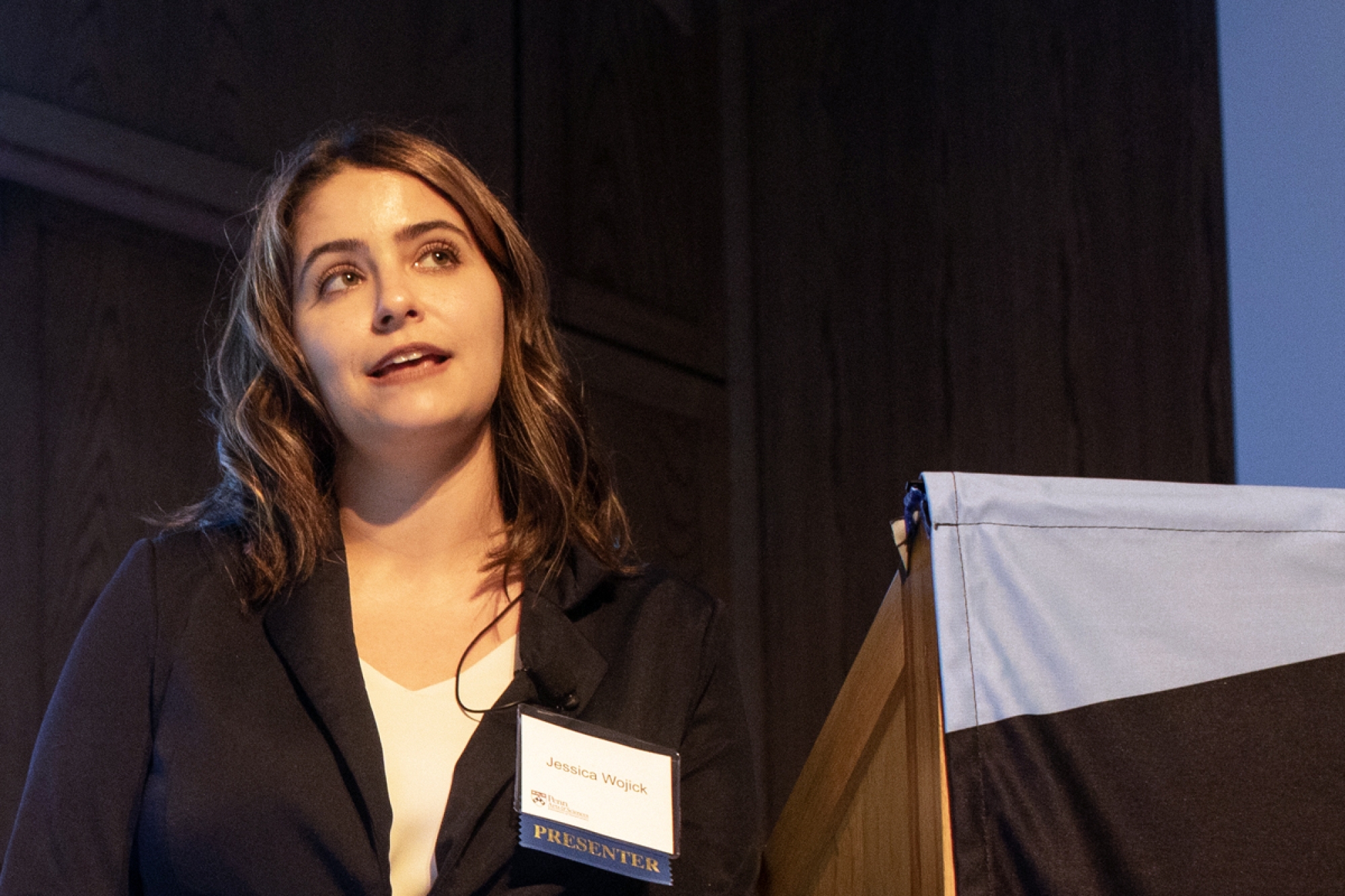 Jessica Wojick standing at a lecturn giving a talk