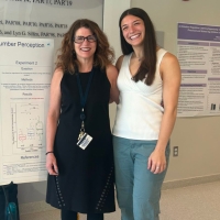 Professor Liz Brannon and Francesca Luzzi stand in front of a poster detailing research Luzzi conducted.
